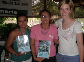 Kelly Quinn delivers copies of Donde no hay Doctor to 2 health promoters in Nicaragua.