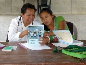 Mateo and girl looking at a Hesperian book