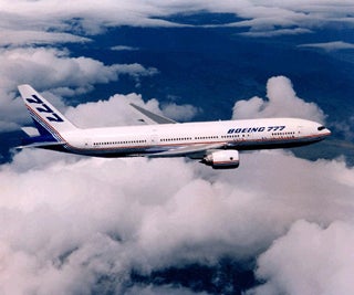 A photograph of a Boeing 777 in flight.