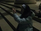 Photo of a student sitting outdoors at night and looking through a lens.