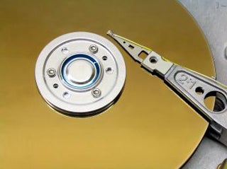 A photograph of a platter and actuator arm from a computer hard drive.