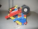 A triangular-framed robot, with wheels on two sides.