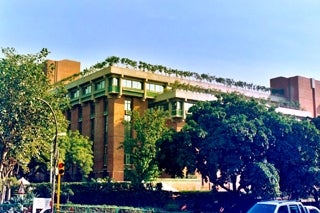 A building at a university that has trees planted on the roof. 